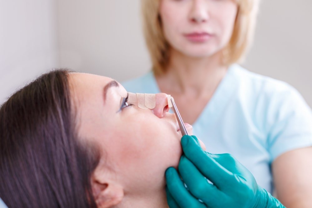 doctor_removing_rhinoplasty_surgery_bandages