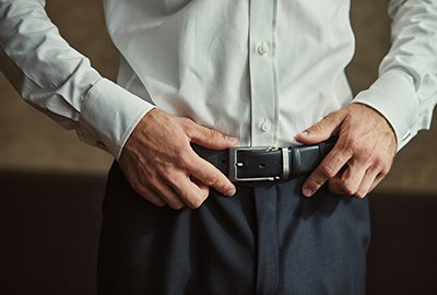 man_holding_belt_on_waist_after_penoplasty_in_turkey