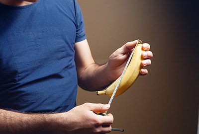 man_measuring_banana_with_tape