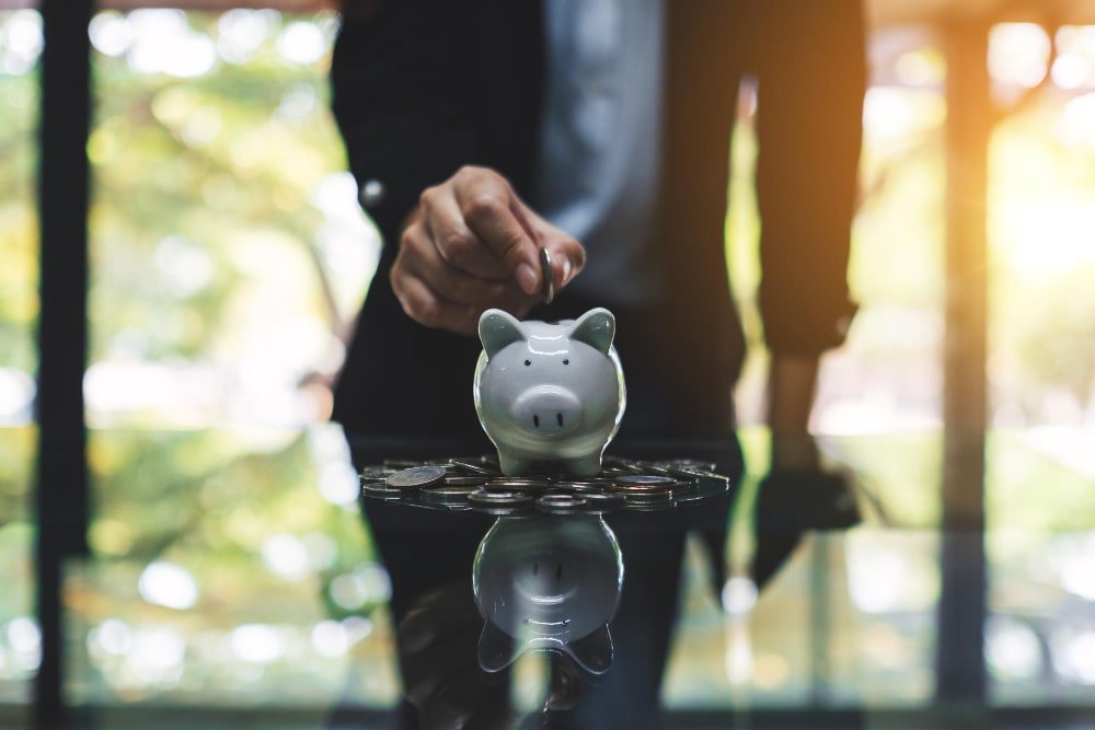 man_putting_money_in_piggy_bank_for_dhi_in_turkey