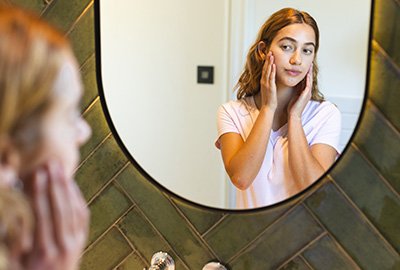 woman_admiring_herself_in_mirror_after_coronal_brow_lift_in_turkey