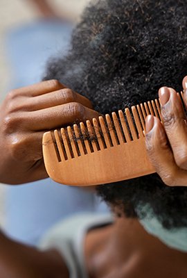 woman_combing_afro_hair_after_afro_hair_transplant_in_turkey